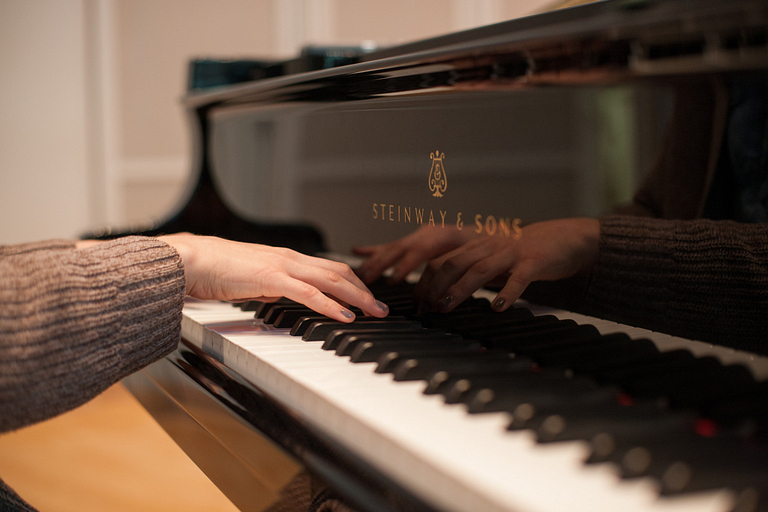 Hands on a piano. 