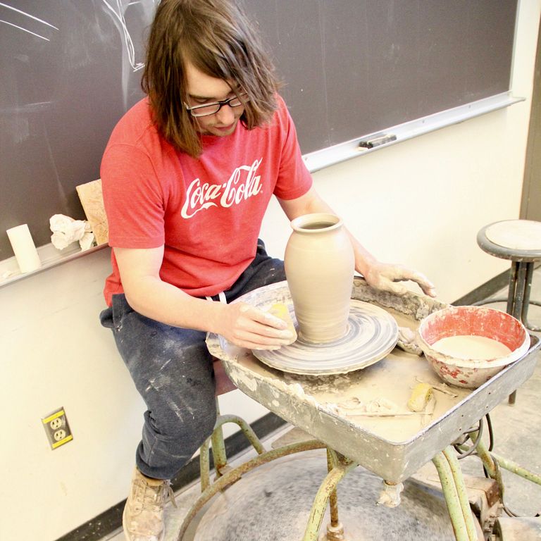 IUPUI senior John Buschbacher creates a vase with a pottery kick wheel.