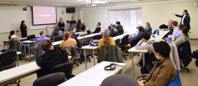 Sameer Patil points from the rear of a classroom during a meeting with Diplomacy Lab officials