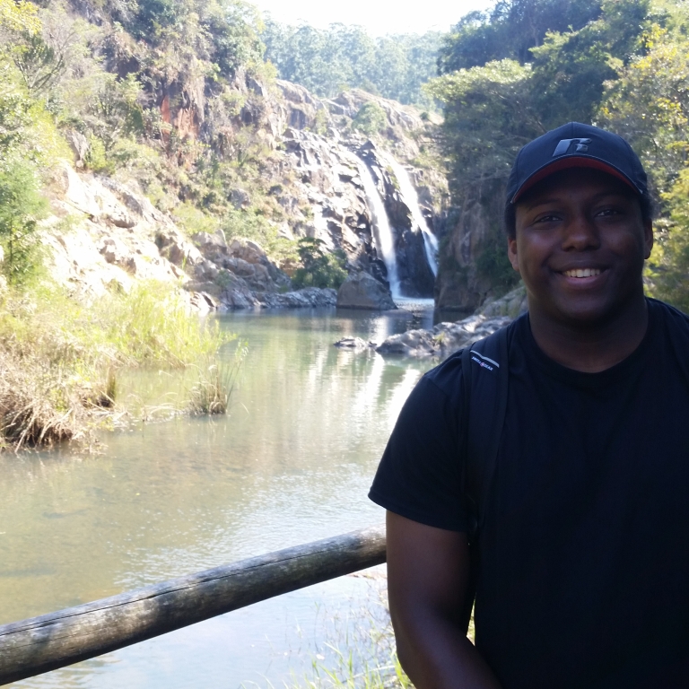 Joseph Boone stands in front of a waterfall.