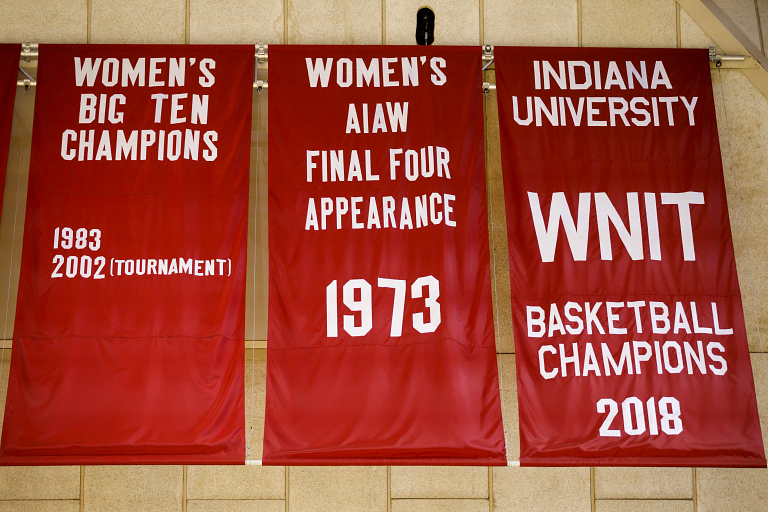Red and white banners for the IU women's basketball program hang from the rafters