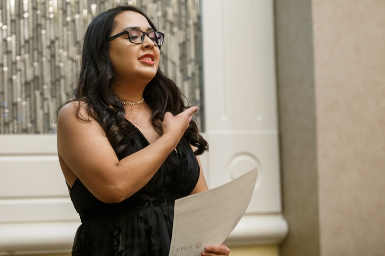 Natalie Mendez shows her sorority hand sign while presenting an award during the installation.