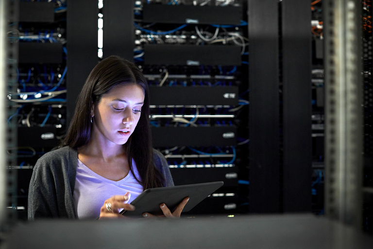 Engineer using a digital tablet in a server room