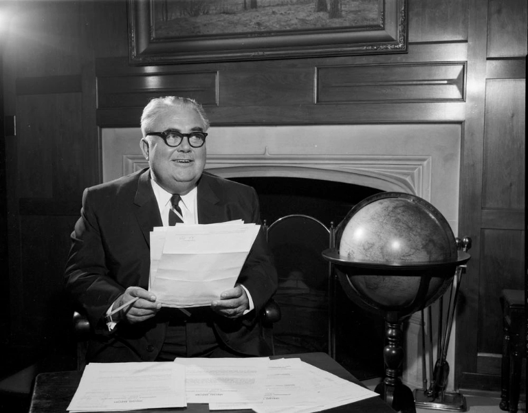 Herman B Wells in his office with a globe