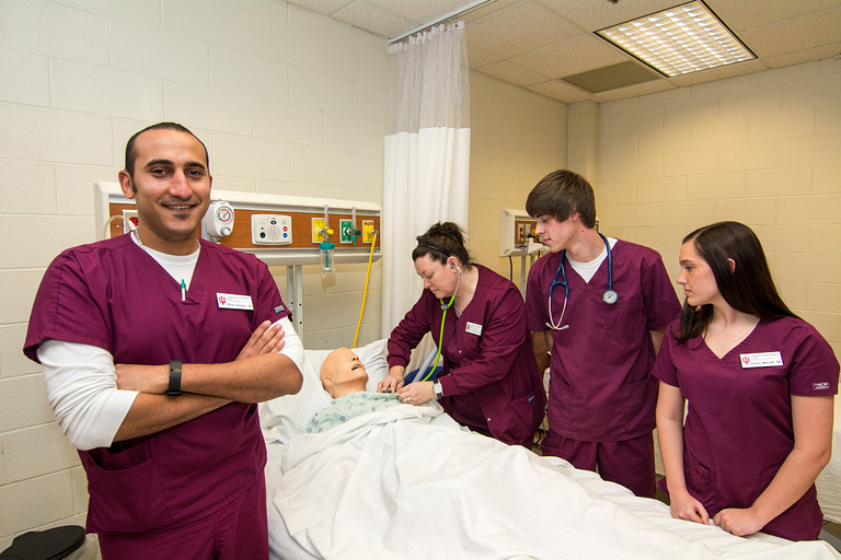 Mina Samaan and other nursing students working with a dummy. 