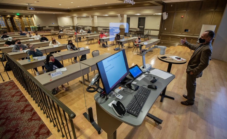 Students attend class in the Indiana Memorial Union with safety precautions in place.
