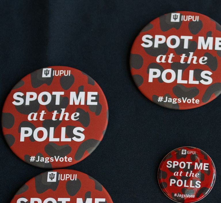 pins and buttons about voting sit on a table