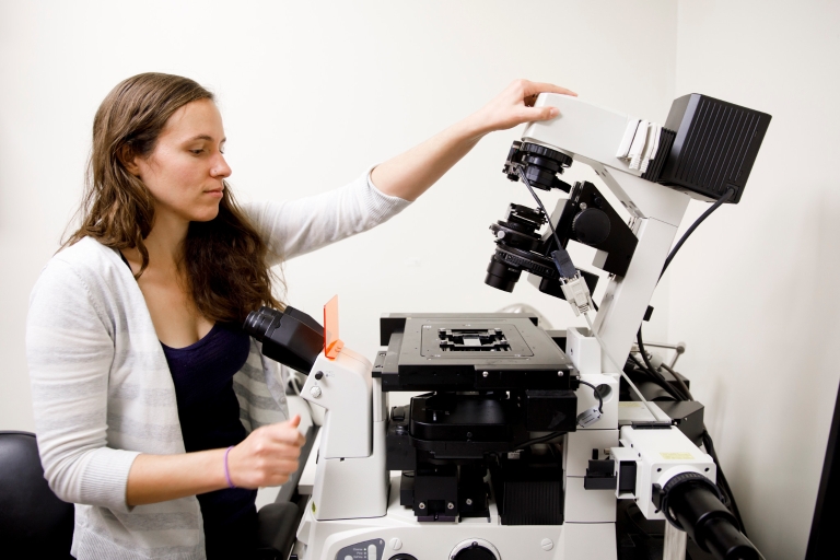 Courtney Ellison uses a fluorescence microscope