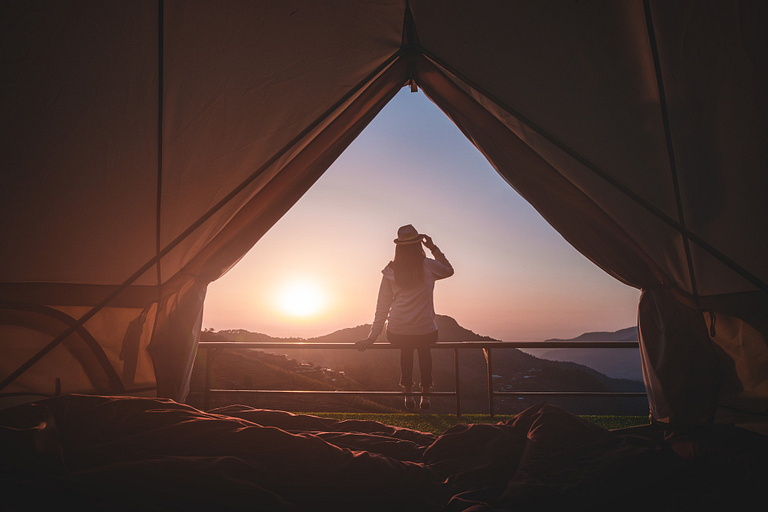 Woman looking at sunset in tent