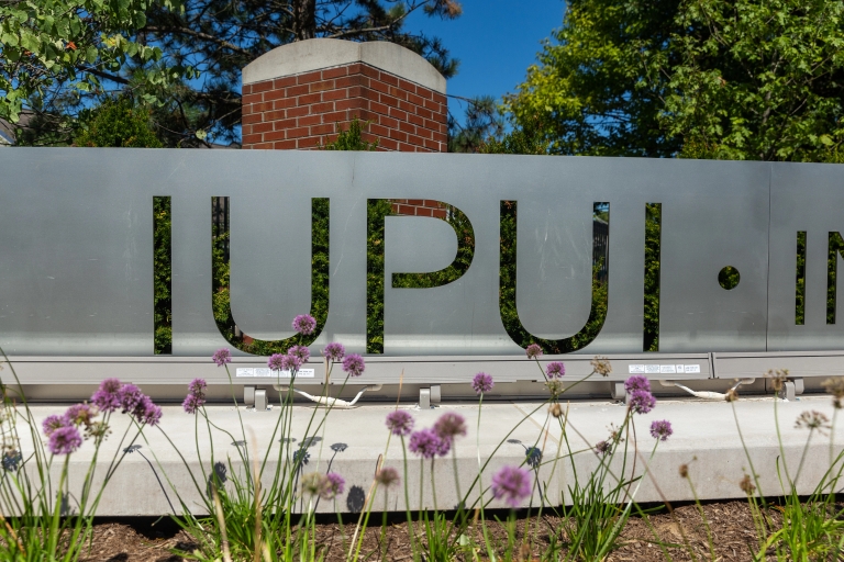 Close up of IUPUI displayed in a limestone gateway sign.