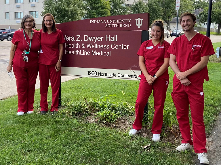 IU South Bend Health and Wellness employees stand next to the center's sign
