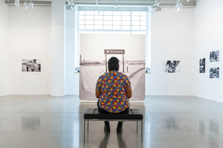 Observer looks at a picture in the Herron Galleries