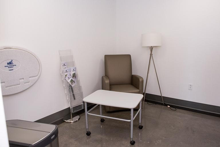 The nursing mothers' room in the Campus Center has a chair, lamp, table and diaper-changing table.
