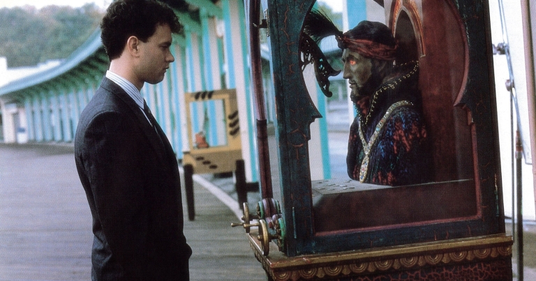 Actor Tom Hanks looks at a genie in an arcade game in a still photo from 