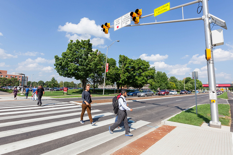 Students walking at a crosswalk on campus
