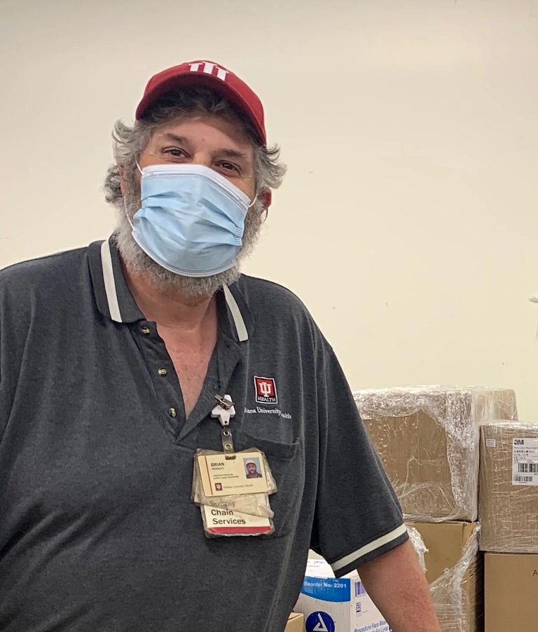 Two men standing with a box of donated items