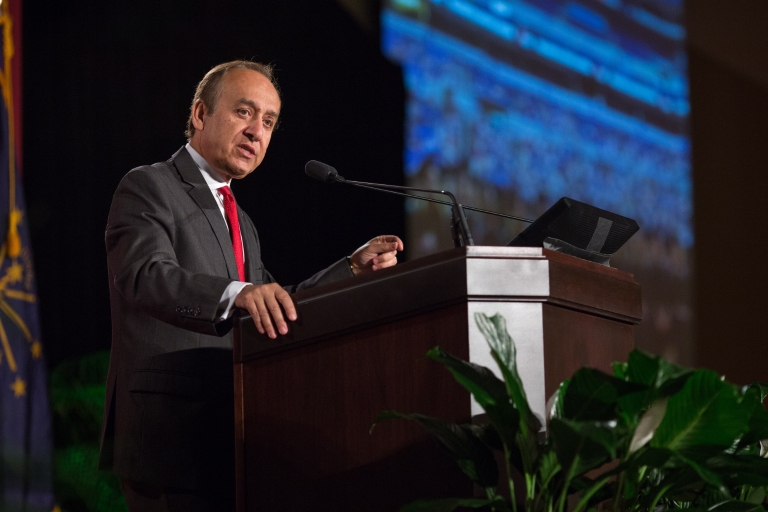 Nasser Paydar stands at a podium as he speaks to an audience about IUPUI