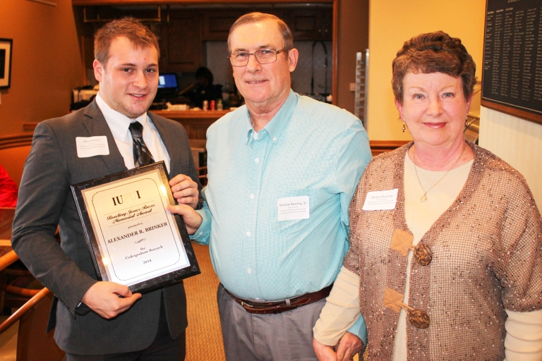 Alexander Brinker receives an award from Michael Sr. and Barbra Bowling.