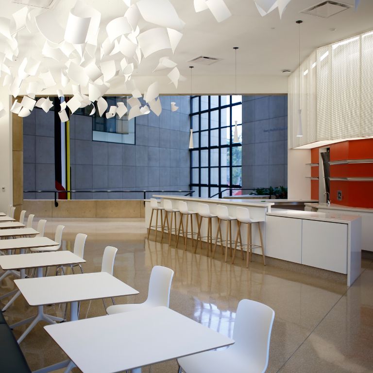 Interior of the museum's new cafe, with a row of tables on the left and kitchen on the right