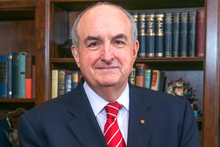 IU President Michael A. McRobbie is pictured in front of a bookcase