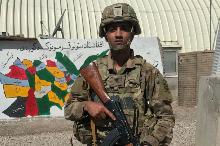 Arsalan Rehman in combat gear holding a rifle