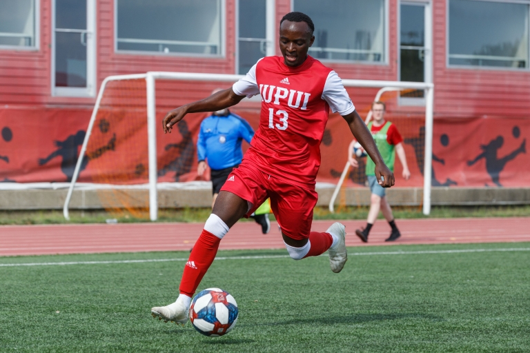 an IUPUI soccer play dribbles the ball during a match