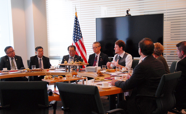 David Sullivan sits at a round table and gives a presentation to a group.