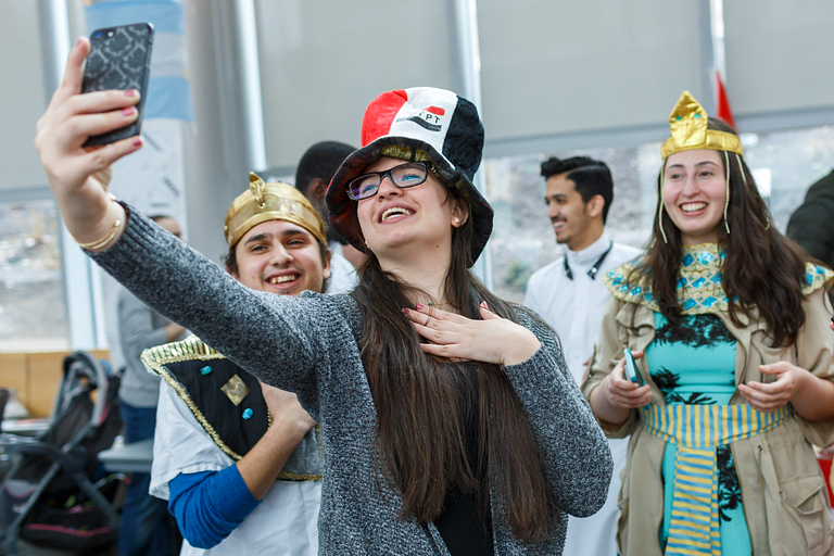 Students wearing silly props while take a selfie with a cellphone