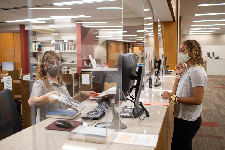 A masked student at Wells Library 