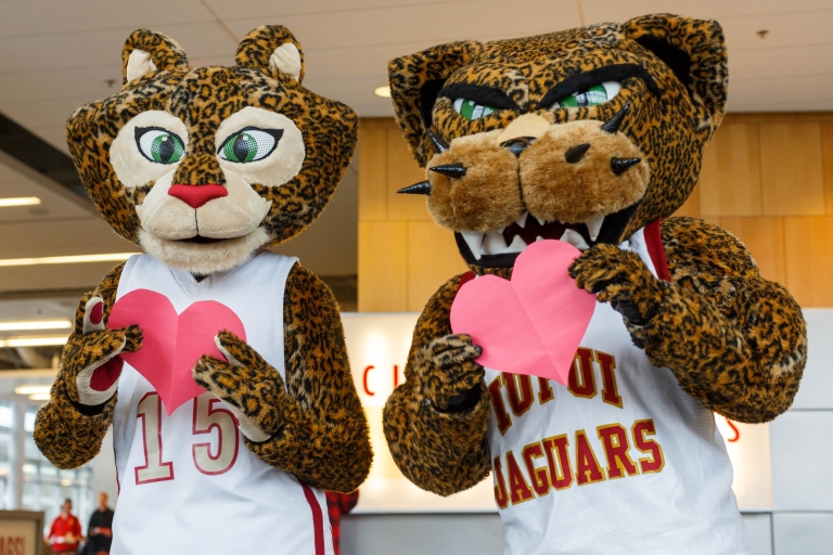 IUPUI jaguar mascots Jazzy and Jaws hold paper hearts