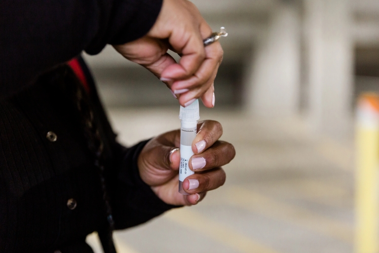 Hands holding a mitigation testing tube