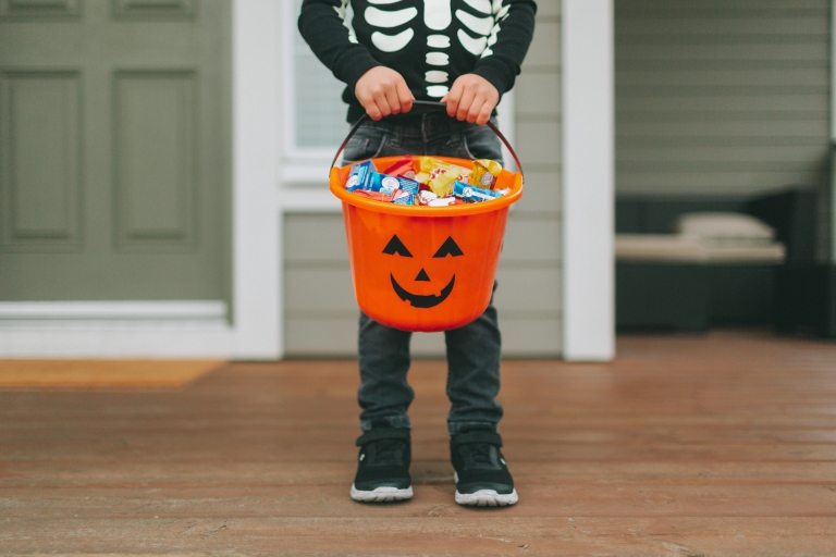 A boy holding a bucket of candy