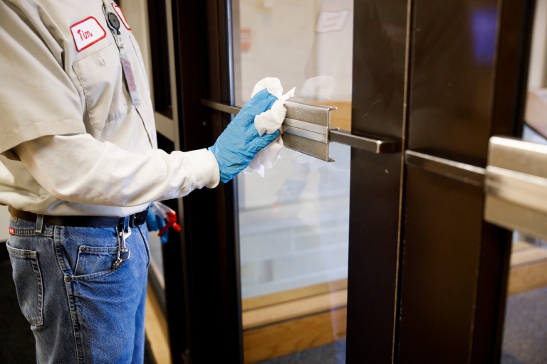 An IU worker wipes down a door