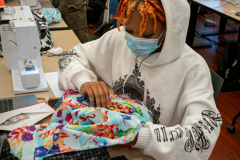 A student works on a tote bag
