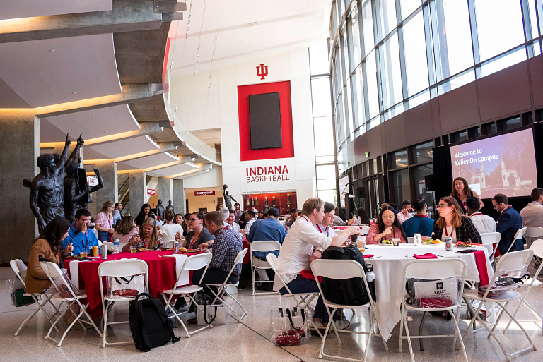 Students eat lunch at tables inside the stadium lobby.