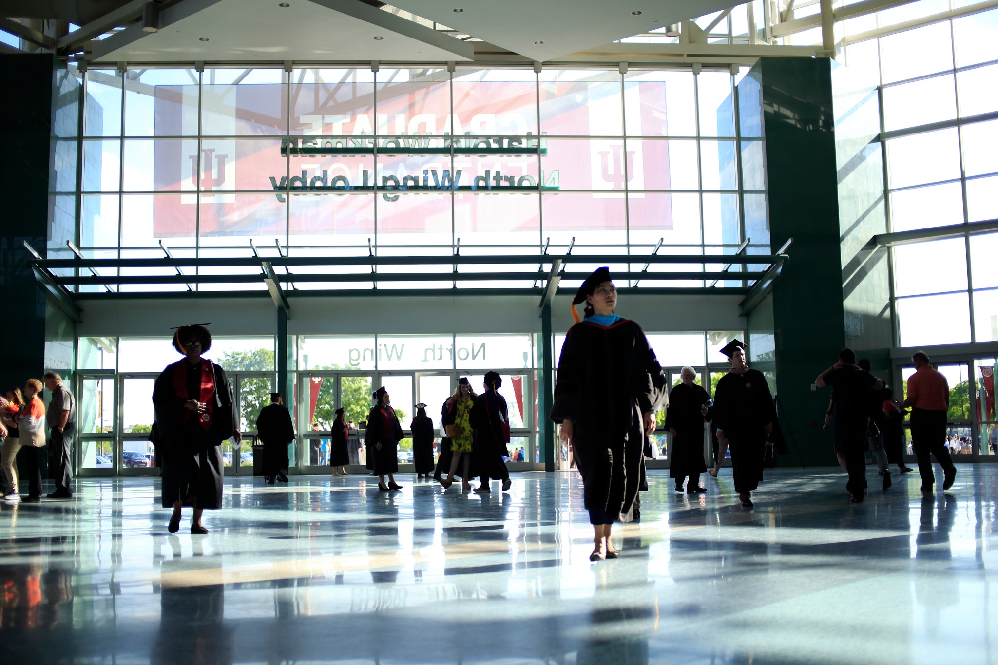 Students walk in caps and gowns to the commencement ceremony