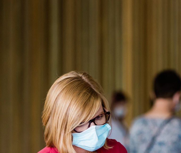 Two people in masks talk during COVID-19 saliva testing at the Barnhill Garage