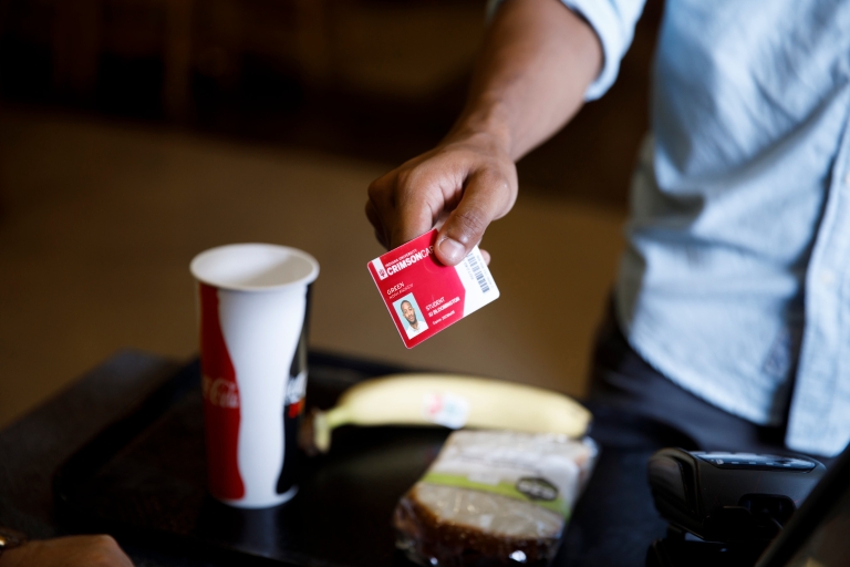 A man pays for food with his student ID.