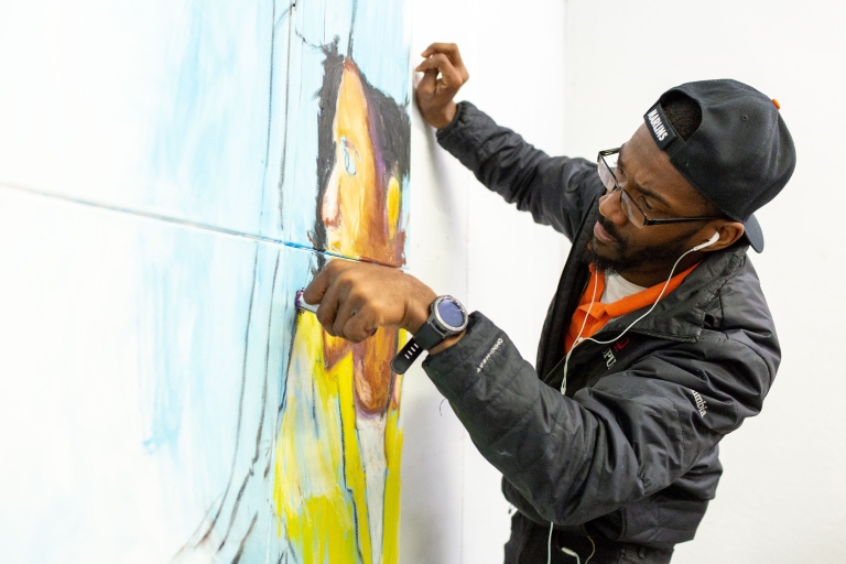 Herron School of Art student Johnson Simon working on a painting in his studio.