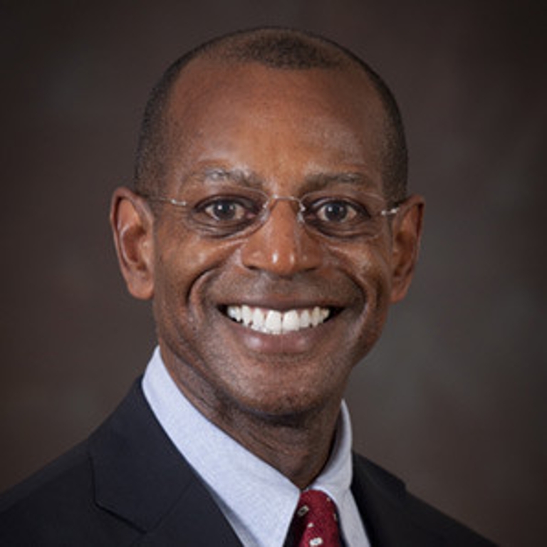 James Wimbush in front of a brown background.