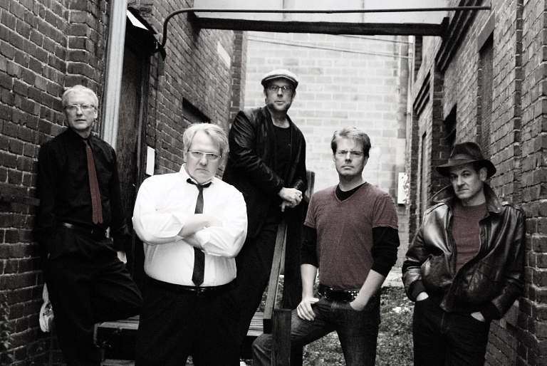 Black-and-white photo of Don't Call Me Betty band members posing in an alley