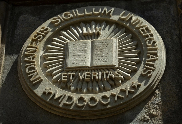 Indiana University 'Lux et veritas' seal on a limestone building