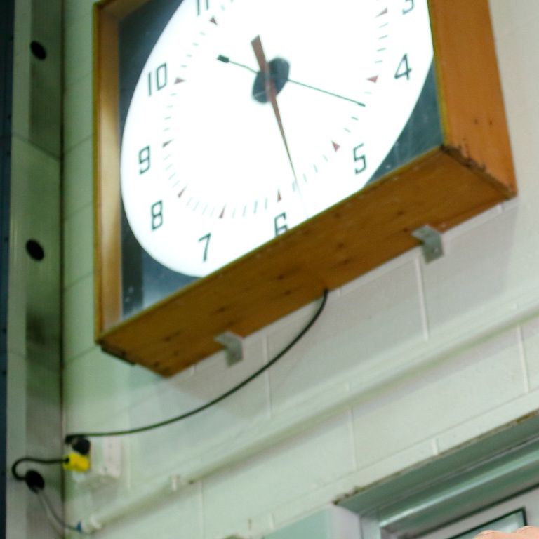 Joel Stager stands under a clock that Doc Counsilman made