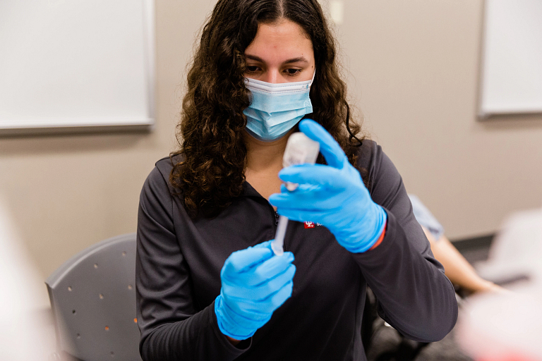 An IU School of Medicine student learns how to administer the COVID-19 vaccine.