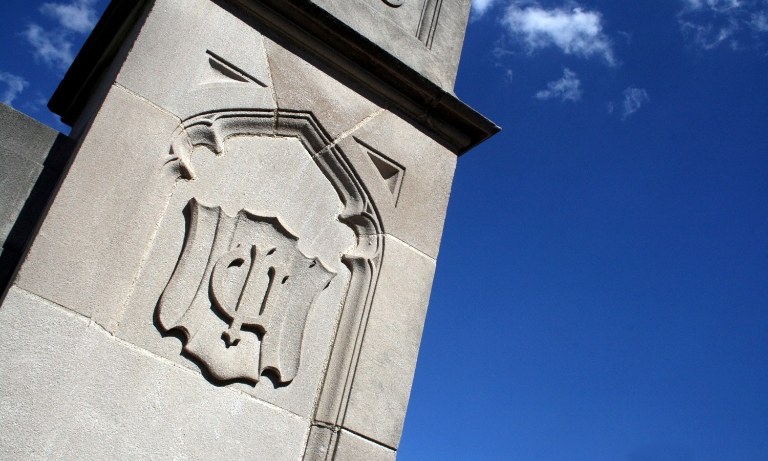 Indiana University limestone pillar against a blue sky
