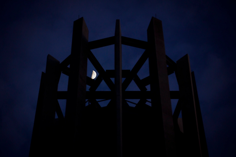 Moon shines through silhouette of carillon