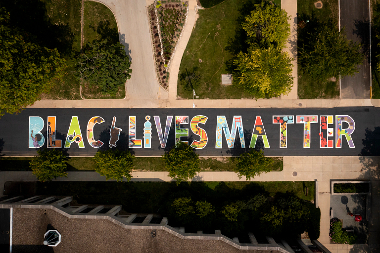 Colorfully painted letters on a street spell Black Lives Matter