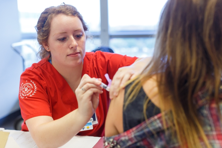 A nurse applies a flu shot.