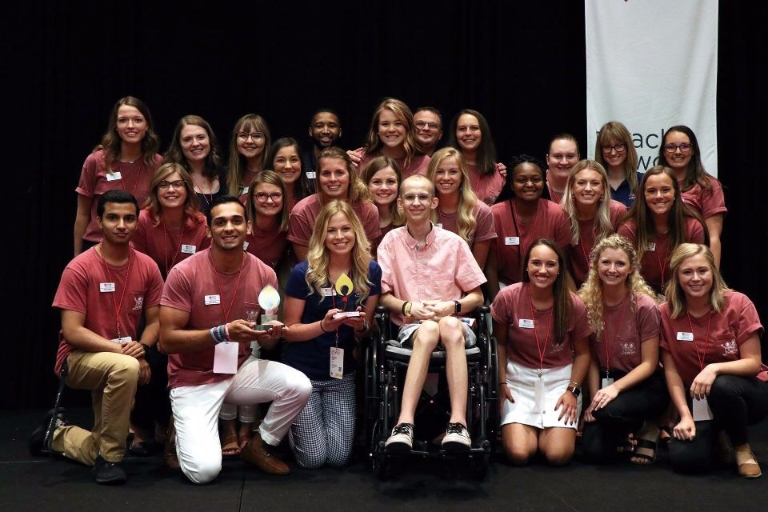 A large group of students with trophies.