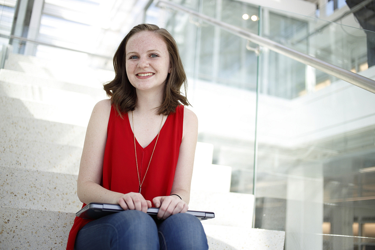 Katie Spoon sitting on the stairs in Luddy Hall.